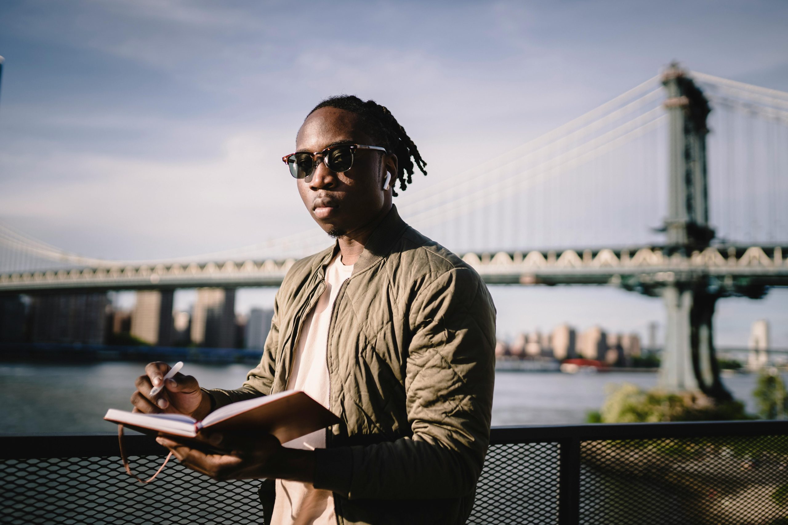 Serious African American man planning route standing on river embankment